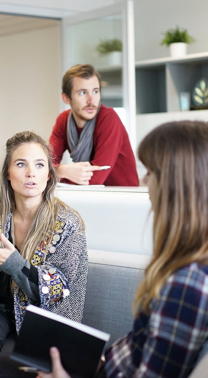 パソコンの前で作業をしている2人の女性と1人の男性
